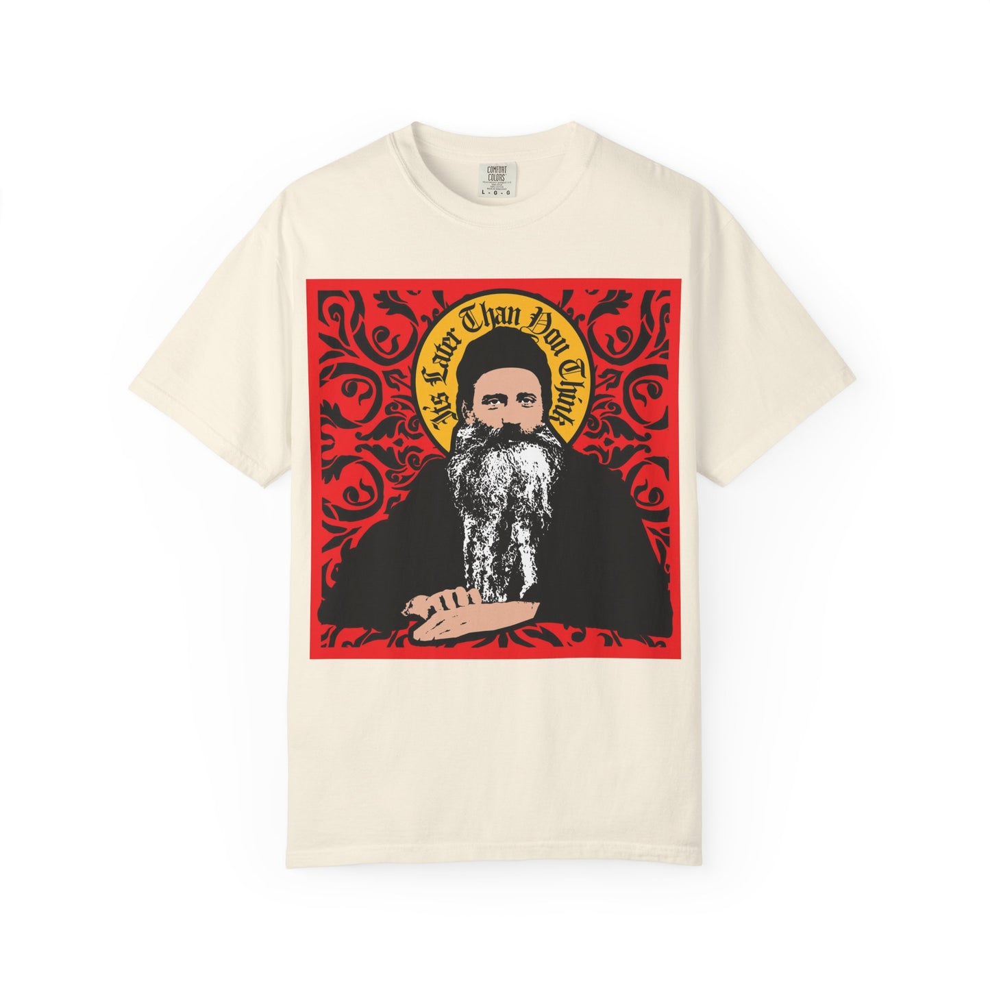 Sporting an ivory heavyweight cotton tee, this design features Saint Seraphim Rose of Platina in a striking icono-graphic style, surrounded by a red ornate border and the phrase "It's Later Than You Think" above his head—a tribute celebrating Orthodox faith and revered figures.