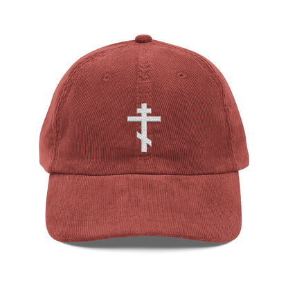 Rust-colored corduroy cap featuring the Simple White Orthodox TriBar Cross embroidered on the front—a subtle nod to faith and unseen spiritual warfare.