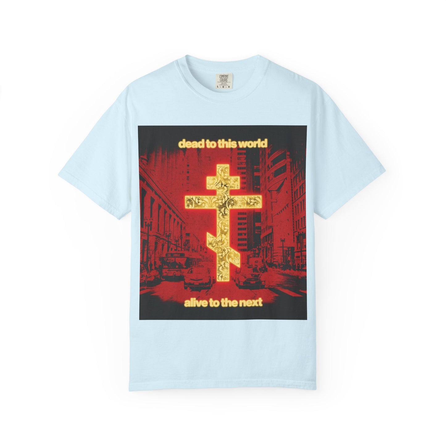 Chambray heavyweight cotton unisex tee featuring a glowing gold cross, red cityscape graphic, and the text: “dead to this world, alive to the next”—a striking Orthodox Christian statement inspired by St. Ignatius on destiny and eternity.