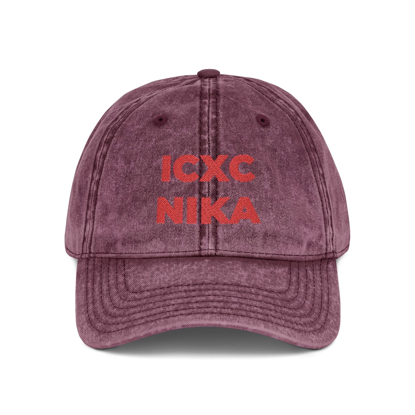 Maroon distressed denim cap embroidered with the red ICXC NIKA Greek Christogram—Orthodox Christian symbol meaning "Jesus Christ Conquers.