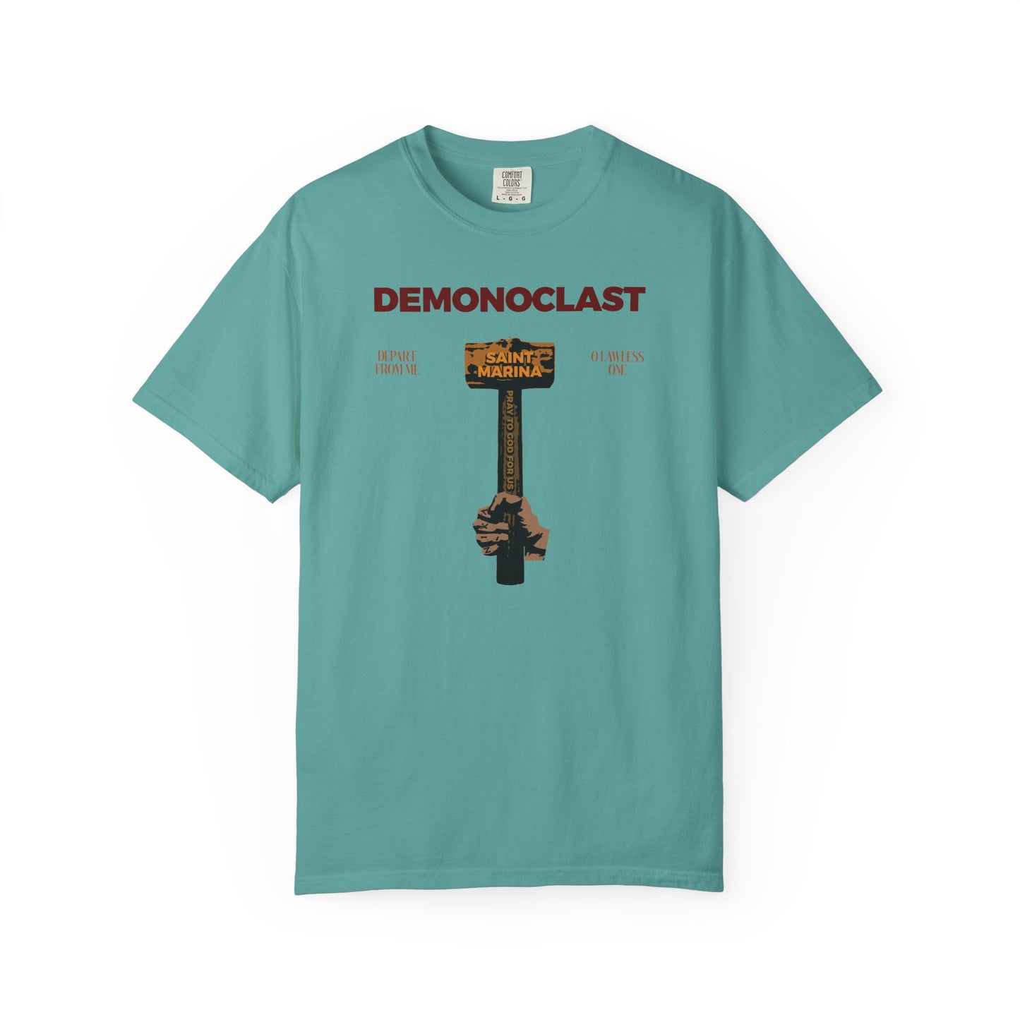 A seafoam heavyweight cotton tee featuring "DEMONOCLAST," a NIKA fist holding St. Marina’s hammer, and motifs of martyrdom, Christ conquers, and unseen warfare. Unisex Orthodox design inspired by the Great Martyr Marina.