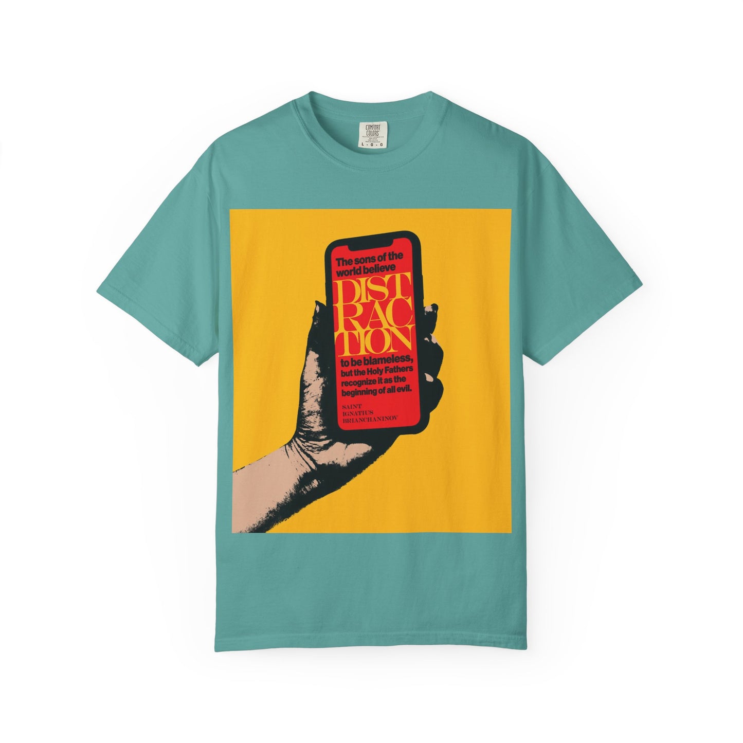 A seafoam heavyweight cotton unisex tee featuring a graphic of a hand holding a phone with red text on a yellow background, inspired by the wisdom of St. Ignatius Brianchaninov from “The Field” and titled “Distraction is the Beginning of All Evil.”.