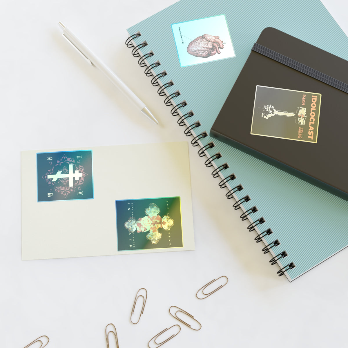Bestseller Mix No. 2 Four Orthodox Stickers on a white desk with notebooks, a pen, and paper clips.