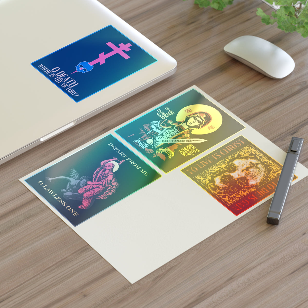Bestseller Mix No. 1 features four Orthodox stickers—Theotokos Champion Leader, St Marina, Death Where is Thy Victory, and To Live is Christ—arranged on a desk next to a laptop, pen, and computer mouse.