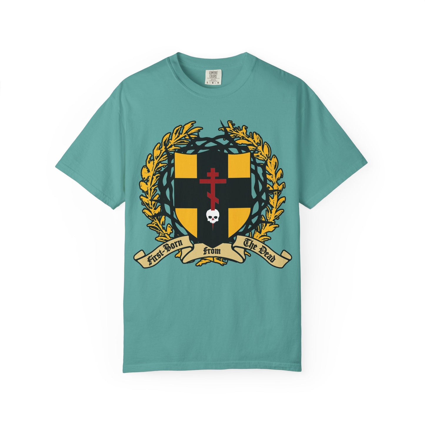 Seafoam heavyweight cotton unisex t-shirt featuring a black and gold heraldic shield with a crown of thorns, Orthodox cross piercing a skull, laurel wreath, and banner reading “First-Born from the Dead”—a bold design inspired by Colossians 1:18 and the story of redemption echoing Exodus.