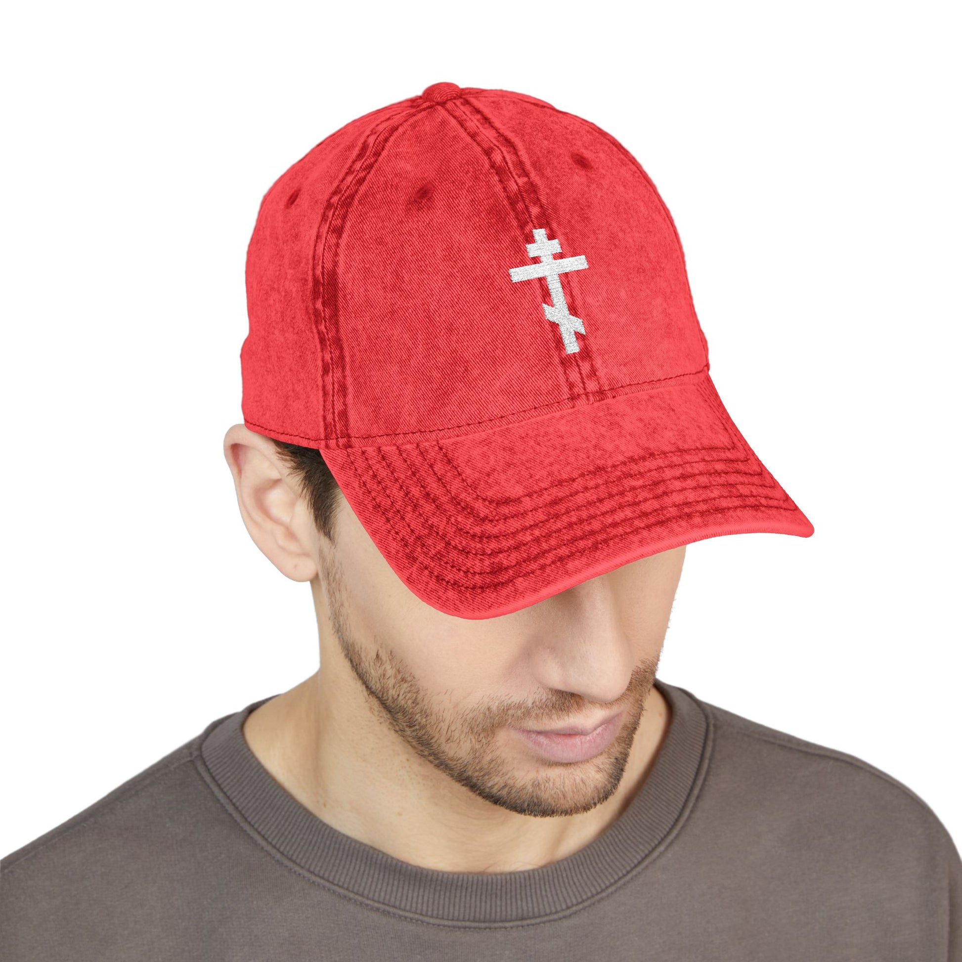 A man wearing the Simple White Orthodox TriBar Cross cap, embroidered with "Crucify My Ego to the Precious and Life Giving Cross," looks down in quiet reflection, honoring the Saviour’s sufferings.