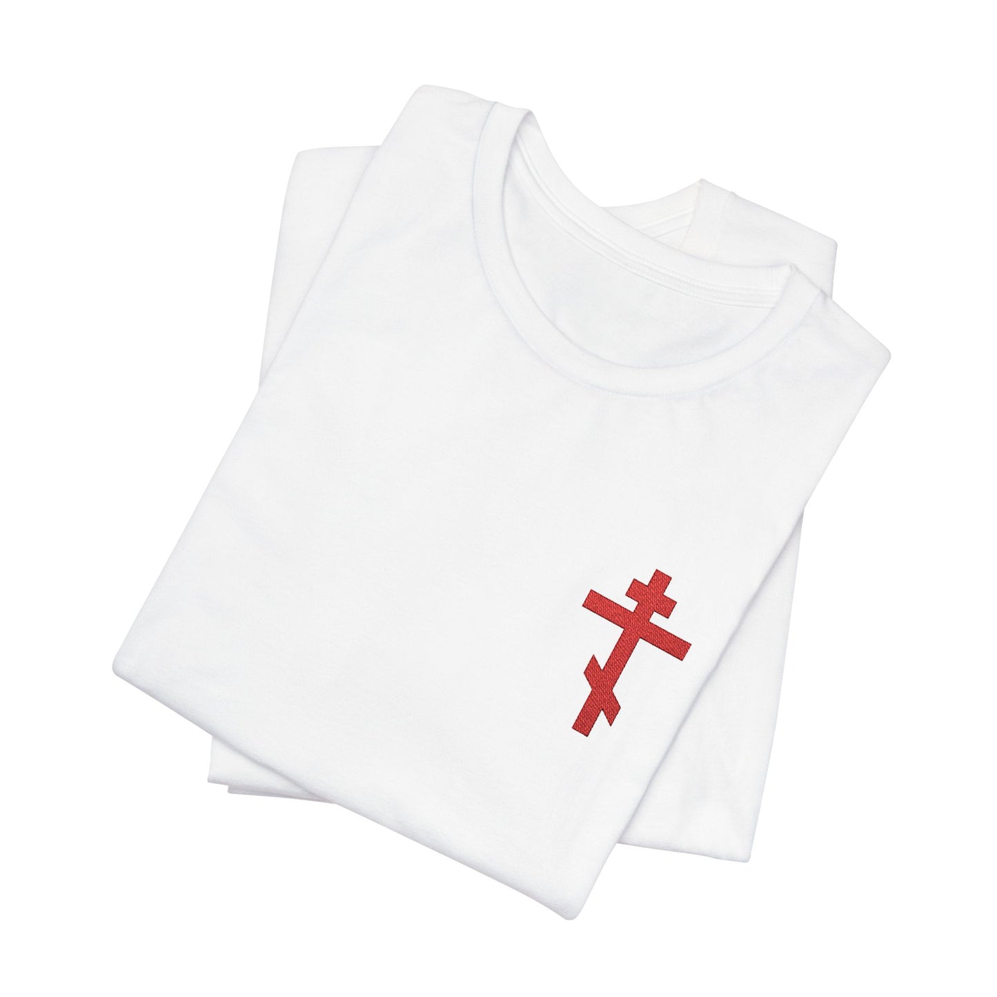 A folded white cotton unisex T-shirt features a small red embroidered Orthodox cross, inspired by Galatians 6:14 and the message "May I Never Boast Except in the Cross.