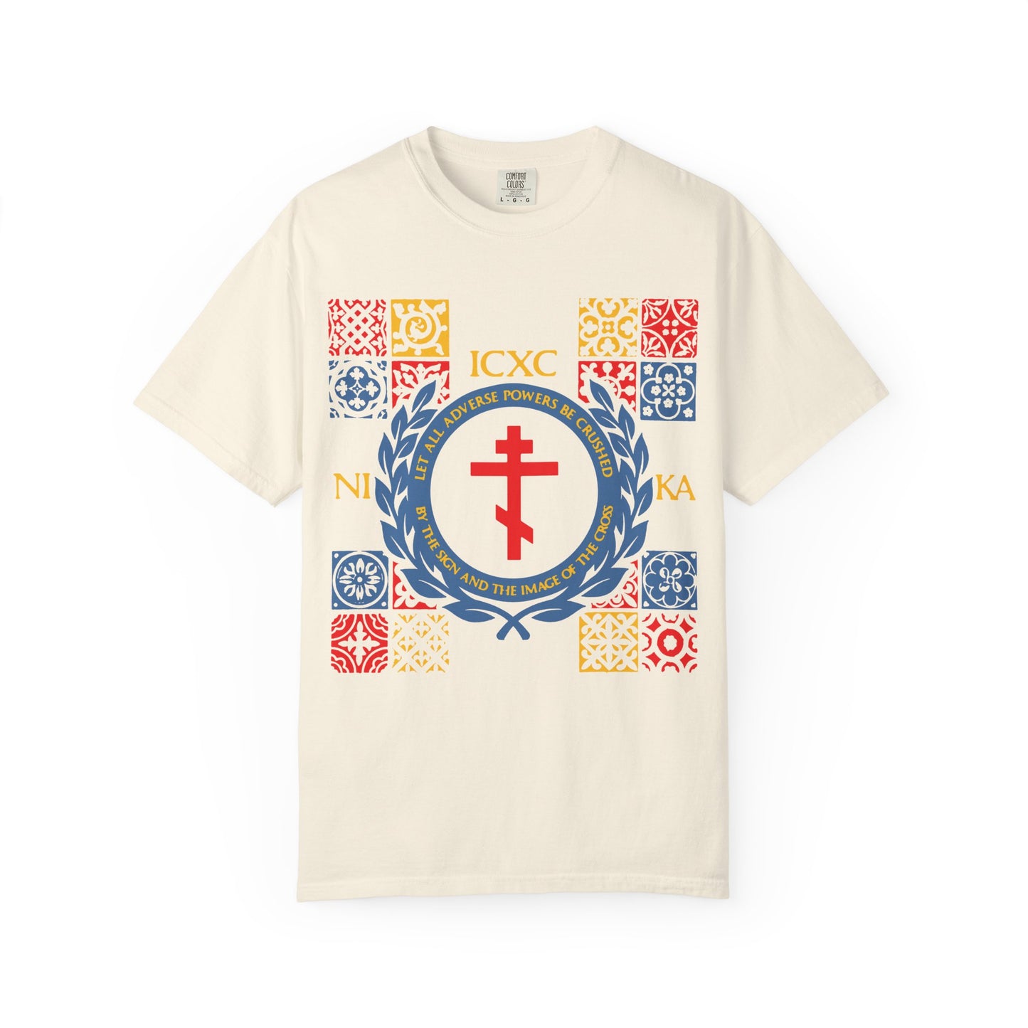Ivory unisex heavyweight cotton T-shirt featuring a bold red cross, vibrant yellow and blue medieval tile patterns, and the ICXC NIKA insignia—a unique piece inspired by Katavasia, titled "Let All Adverse Powers Be Crushed.