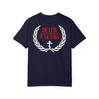 Certainly! Here’s a rewritten sentence using the provided product data: The Archangel Michael of the Apocalypse Iconographic / Death is Swallowed Up In Victory DOUBLE-SIDED Heavyweight Cotton Orthodox Unisex Tee features a navy design with a white laurel, bold red “Death is swallowed up in victory” text, and a white cross motif, drawing inspiration from the Miracle of Archangel Michael and Revelation 12.
