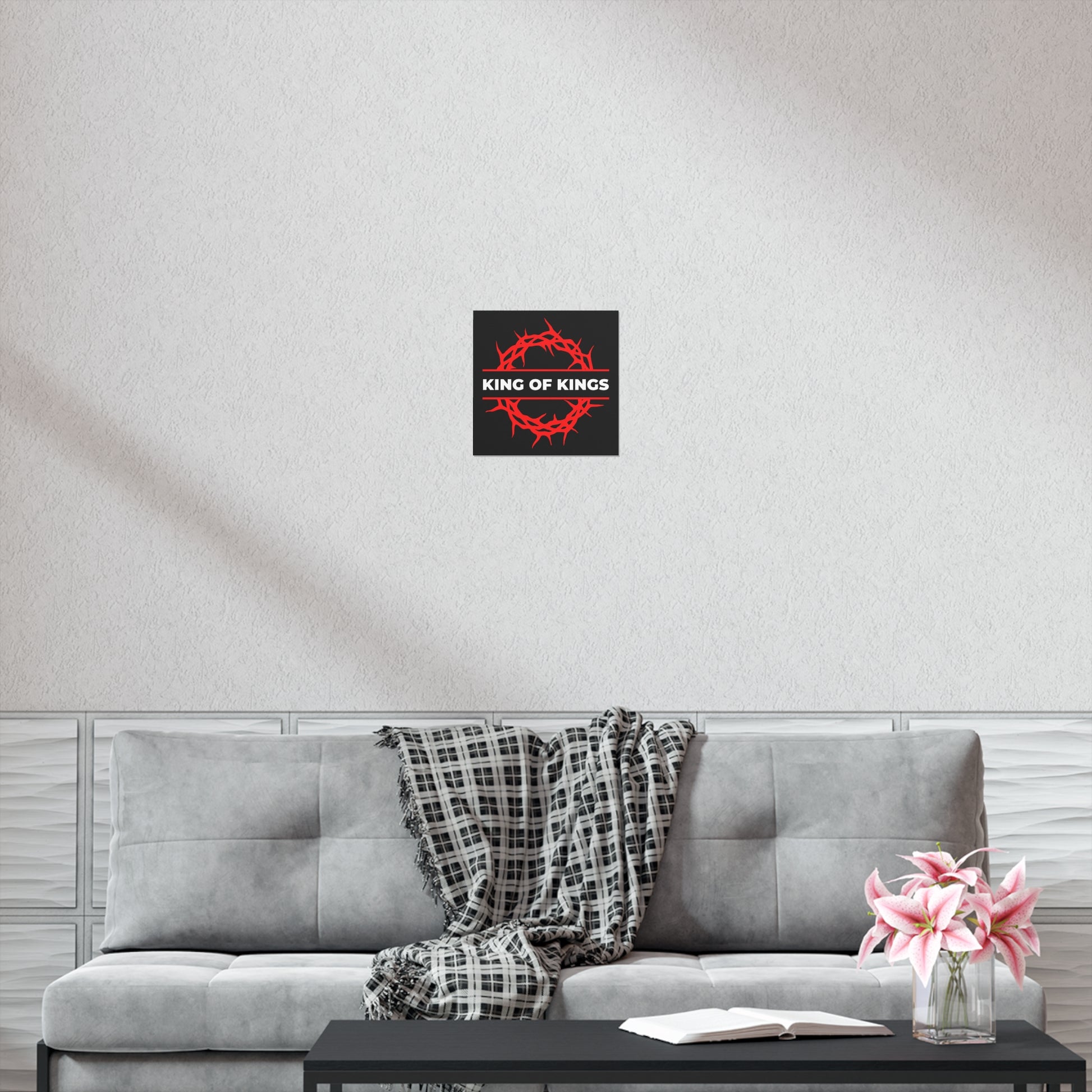 Modern living room with gray sofa, plaid throw, flowers on table, and "King of Kings Crown of Thorns | The King of Glory | Christ is King | Revelation 19:16" Uncompromising Christian Art Poster above the sofa.