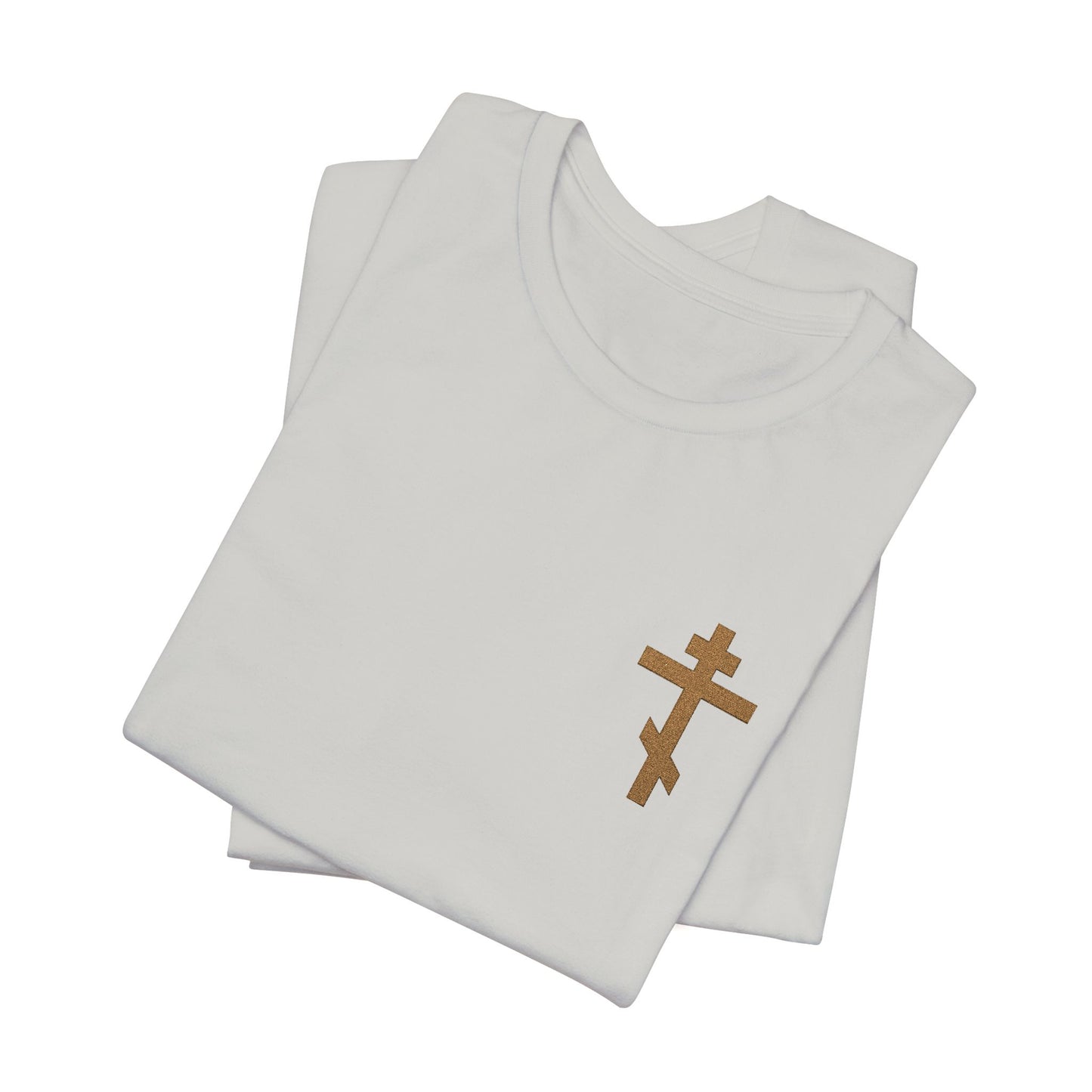 Two folded earthtone unisex cotton t-shirts with a small embroidered Orthodox cross, inspired by Galatians 6:14—“May I never boast except in the cross.”.