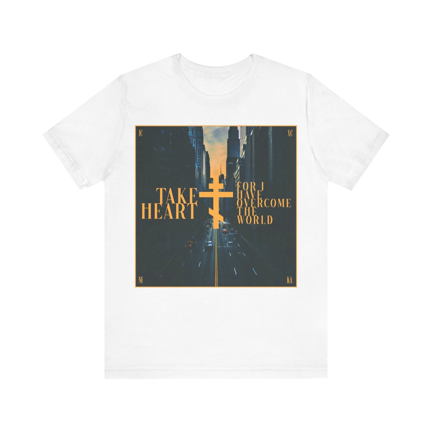White cotton t-shirt with a modern city street scene and gold text: "Take Heart, For I Have Overcome the World" (John 16:33). Orthodox Christian design that reminds you joy follows sorrow.