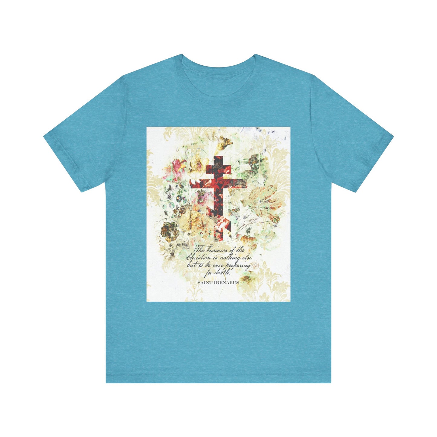 Heather Aqua T-shirt featuring a white and beige floral scrapbook-style cross graphic with cursive text at the center, inspired by St. Irenaeus and the Christian tradition of preparing for death.
