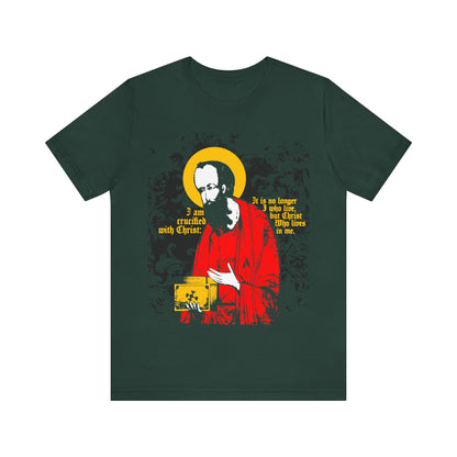 Forest-colored "St Paul Holding Gospel Iconographic" Orthodox Christian T-shirt, featuring St Paul with a yellow halo, small gospel, and the text "I am crucified with Christ" (Galatians 2:20), symbolizing new life in Christ.