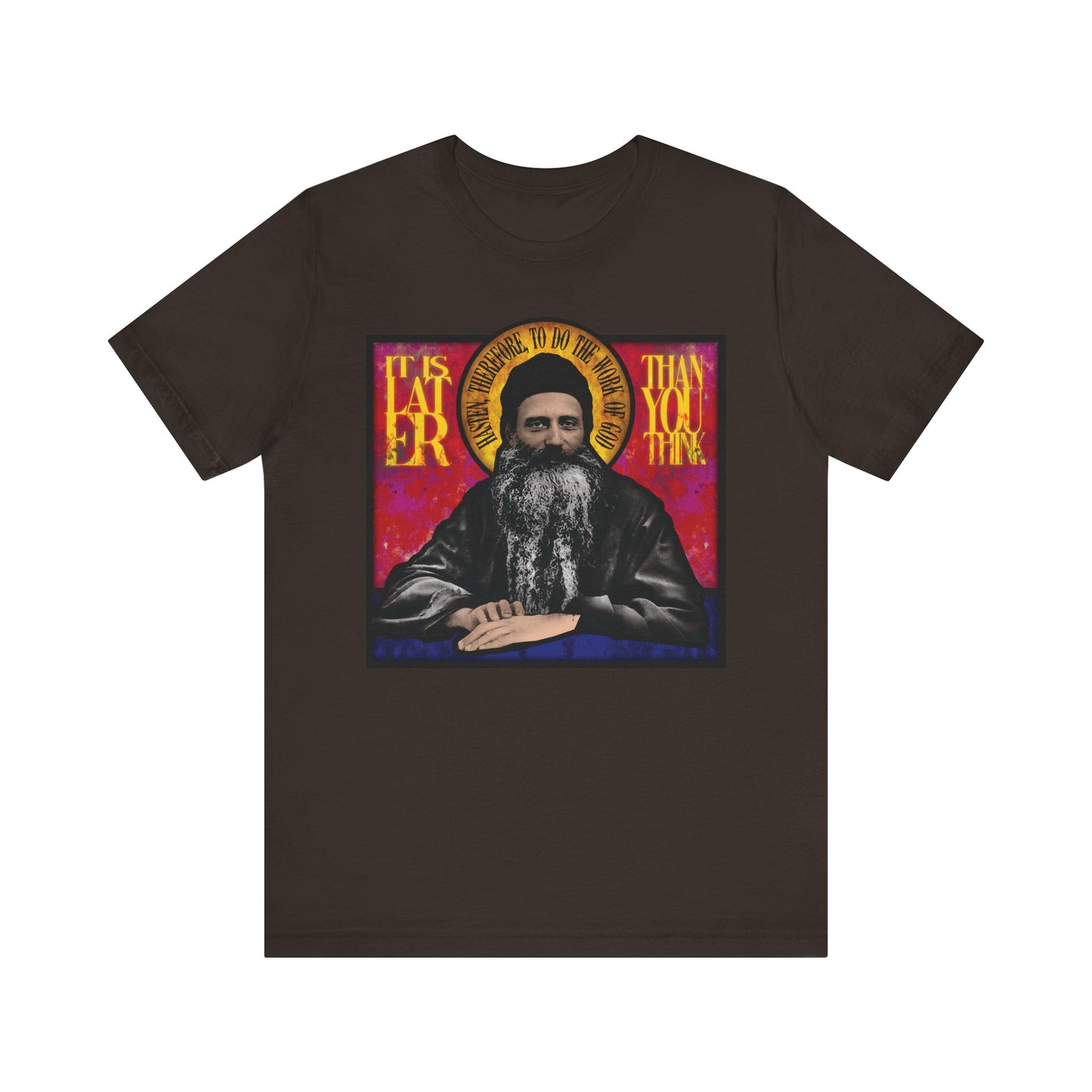 Brown lightweight cotton unisex t-shirt featuring Fr. Seraphim Rose as a stained glass image with the phrase "It Is Later Than You Think"—a vivid reminder of salvation and the urgency to seek the Kingdom of Heaven.