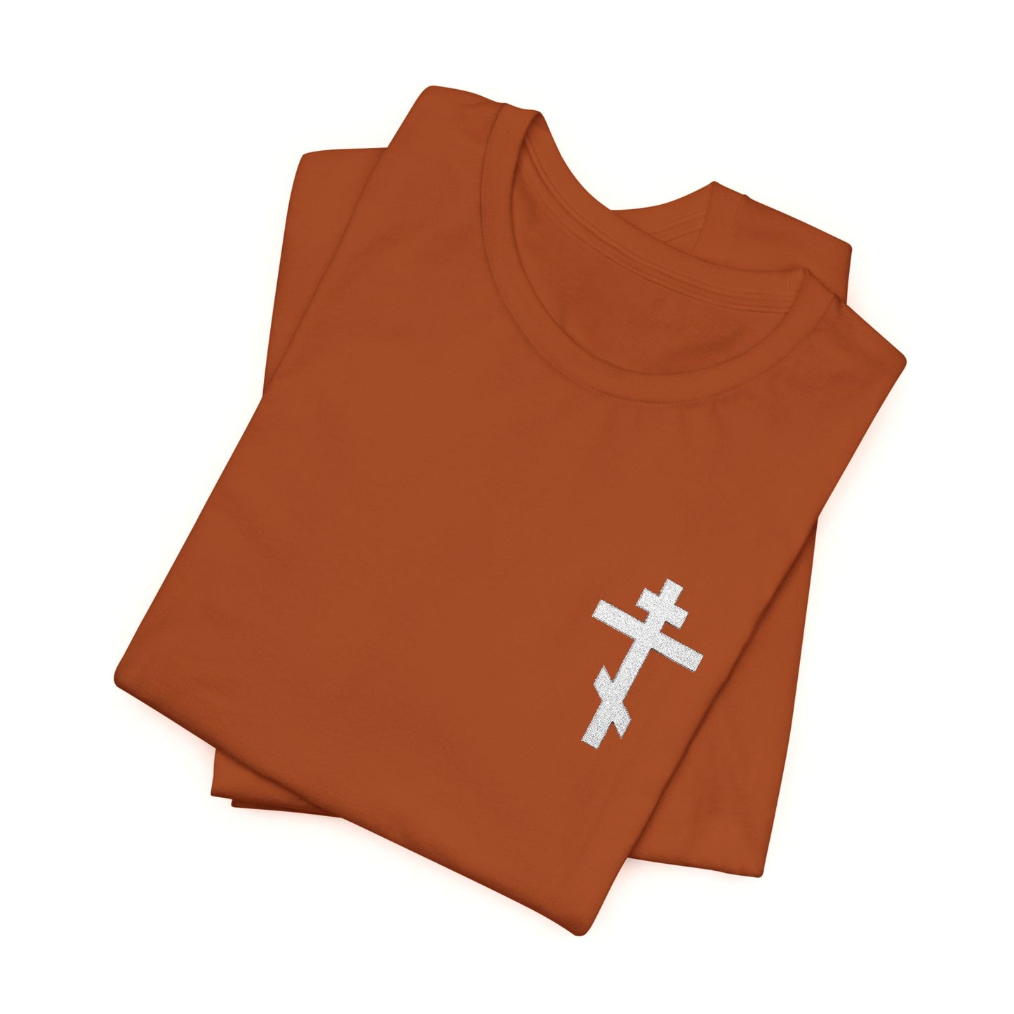 Rust-colored t-shirt featuring a small embroidered white Orthodox cross on the chest and inspired by Galatians 6:14, "May I Never Boast Except in the Cross of Our Lord Jesus Christ," displayed on a white background.