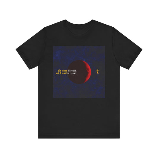 Black unisex tee featuring a red moon, yellow cross, and "He must increase, but I must decrease" (John 3:30) in gothic text. Inspired by John the Baptist. Orthodox Christian design. Lightweight cotton.