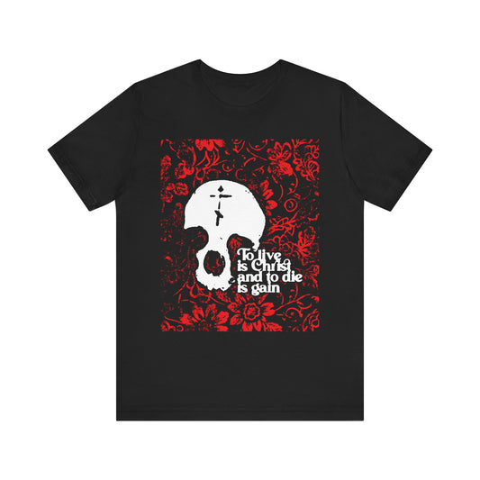 Black unisex cotton tee featuring a striking white skull with a cross over a vivid red floral texture, inspired by Philippians 1:21 and displaying the message "To live is Christ, to die is gain." This Orthodox Christian design powerfully reflects faith in Christ as life itself.