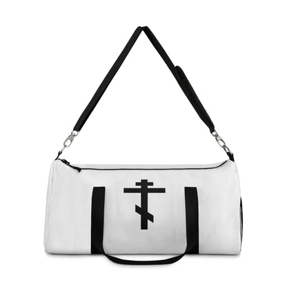 White duffel bag with black handles, featuring a black Orthodox cross and the Galatians 6:14 quote: "May I never boast, except in the cross of our Lord Jesus Christ." Perfect for Orthodox Christians.