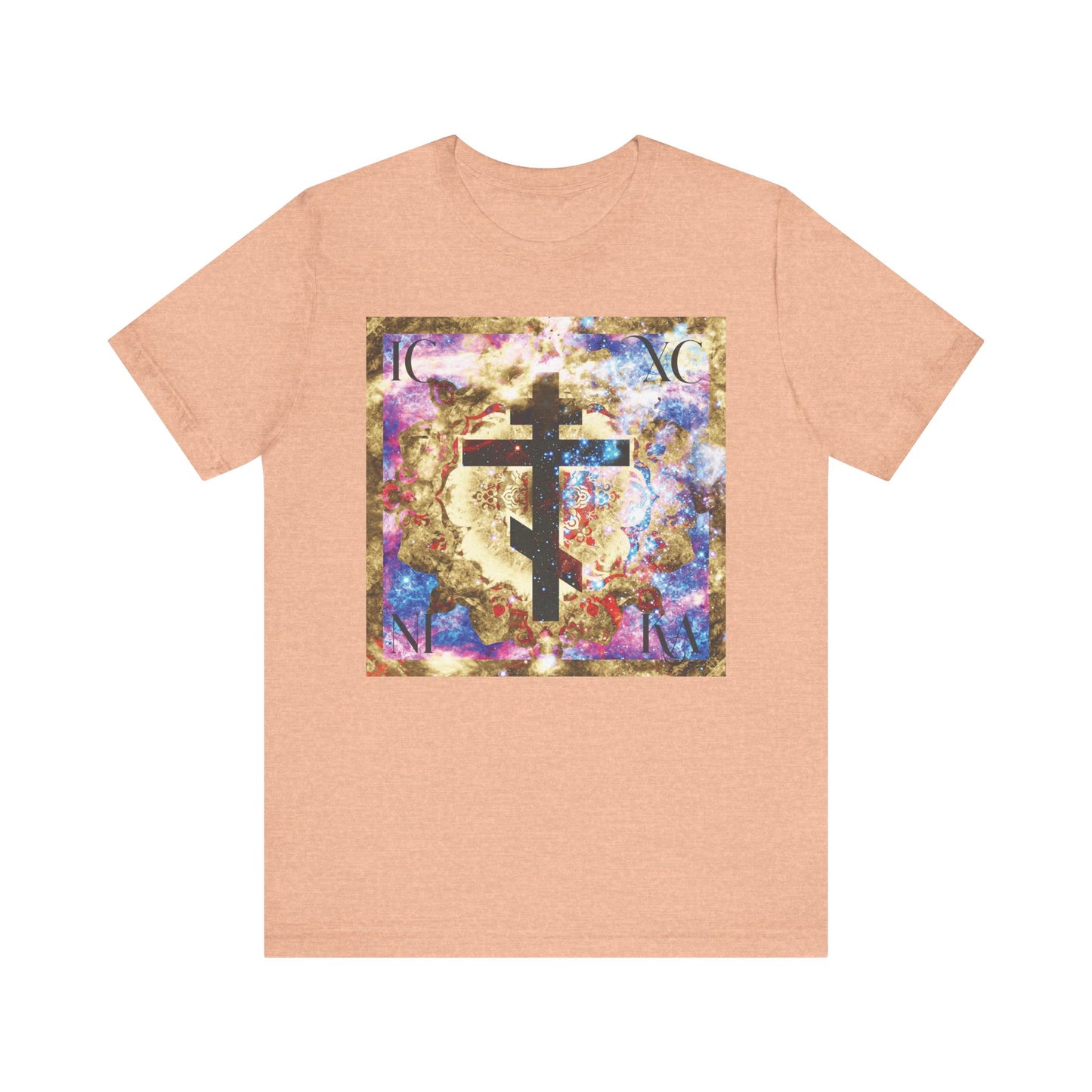 Heather Peach t-shirt featuring a vibrant gold and blue cosmic textured cross with "ICXC NIKA" in the center, symbolizing victory of the Cross and Orthodox Christian faith.