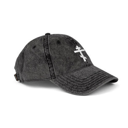 The Simple White Orthodox TriBar Cross Cap is a black distressed baseball hat featuring a white minimalist cross, symbolizing the crucifixion, embroidered on the front.