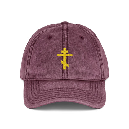 Maroon cap featuring a minimalist yellow Orthodox TriBar Cross and "Crucify My Ego to the Precious and Life Giving Cross" embroidery, symbolizing Christian faith.