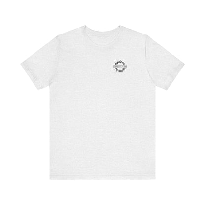 Ash-colored lightweight cotton unisex tee featuring a branded front and "Dead to this World" motif, with a Christian goth flower cross & skull design. Ideal for those seeking simplicity and renunciation of worldly things.