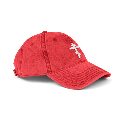 The Simple White Orthodox TriBar Cross cap features a minimalist distressed embroidered cross design, symbolizing Christ's sacrifice, and is displayed against a white background.