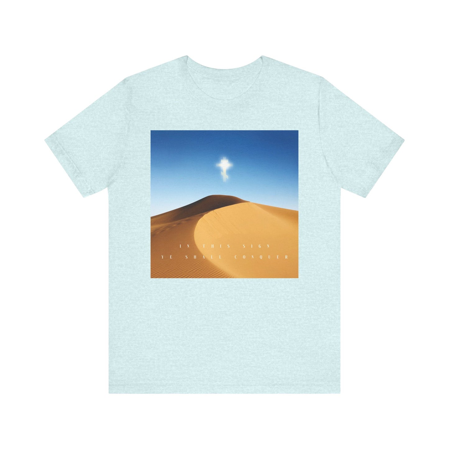 Heather Prism Ice Blue tee featuring a desert sun scene and the cross; text reads “In This Sign Ye Shall Conquer.” Inspired by the Elevation of the Cross. Lightweight cotton, unisex fit—Orthodox Christian design.