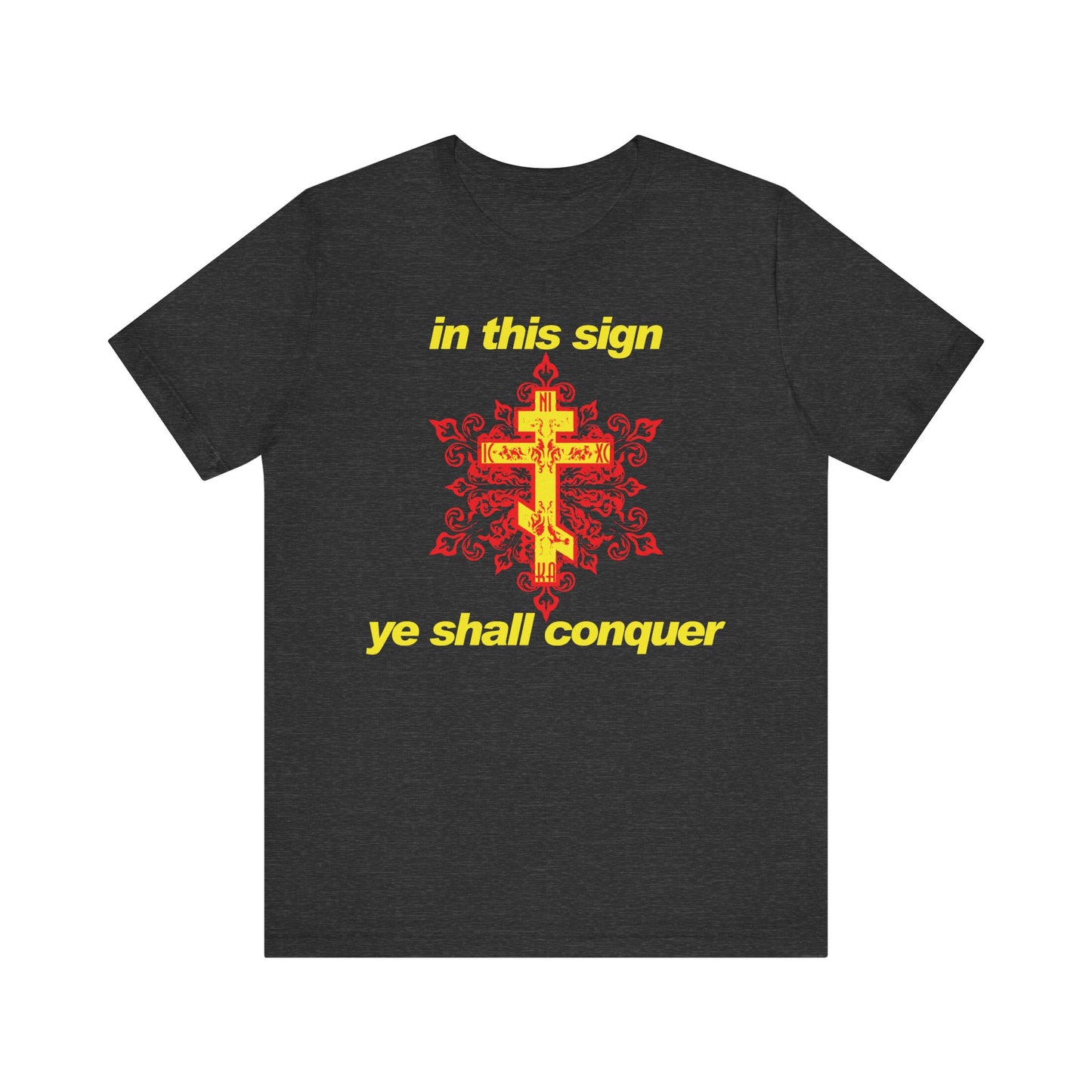 Dark Grey Heather t-shirt featuring a yellow cross, red pattern, and bold yellow text—"in this sign ye shall conquer." Inspired by the spiritual teachings of St. Isaiah the Solitary, this lightweight cotton unisex shirt offers a modern Orthodox Christian design and serves as a subtle reminder to stand firm in faith and use prayer against temptation.