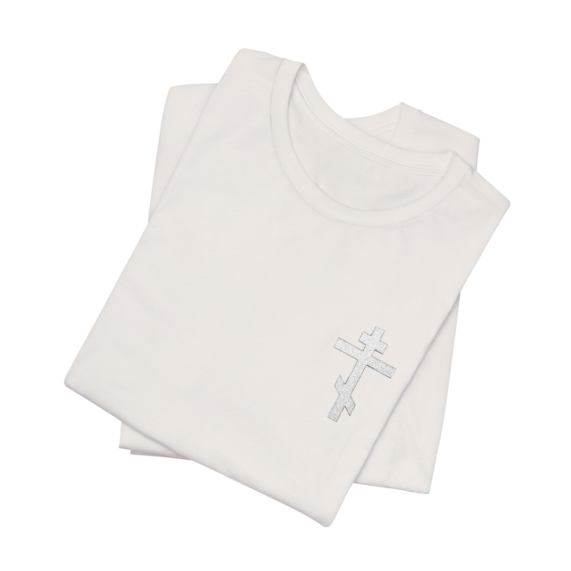 Two folded "White on Light Small Embroidered Orthodox Cross" Christian unisex t-shirts, crafted from premium Airlume combed cotton, are displayed on a white background; the top features a silver Orthodox cross.