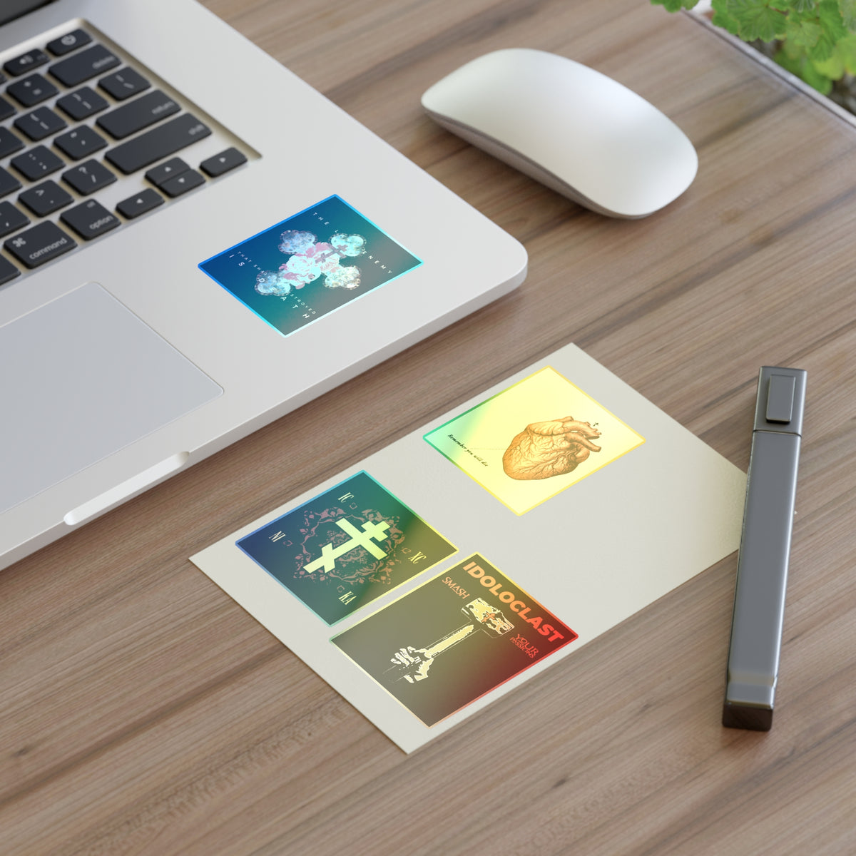 A laptop with Bestseller Mix No. 2 Four Orthodox Stickers, a mouse, plant, and pen on a wooden desk.
