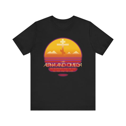 Black cotton unisex tee with 80s aesthetic, featuring an Orthodox cross, sunset, and mountains. Text: "I am Alpha and Omega, the beginning and the end" (Rev 22:13). Christian-inspired design.