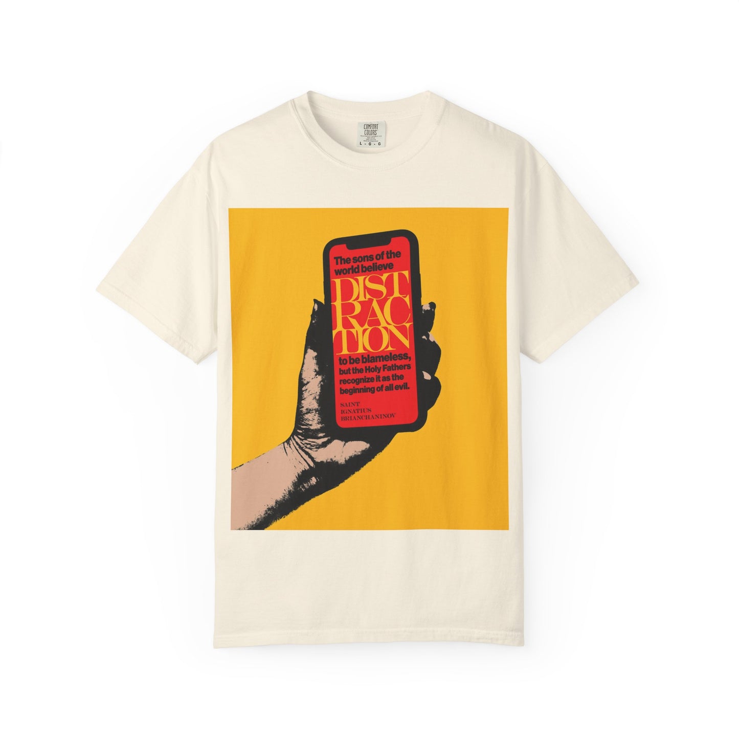 Ivory heavyweight cotton unisex tee, titled “Distraction is the Beginning of All Evil (St Ignatius Brianchaninov) | Mobile Phone Addiction,” featuring a graphic of a hand holding a phone with bold themed text on a yellow background—drawing inspiration from The Field and the teachings of St Ignatius Brianchaninov.