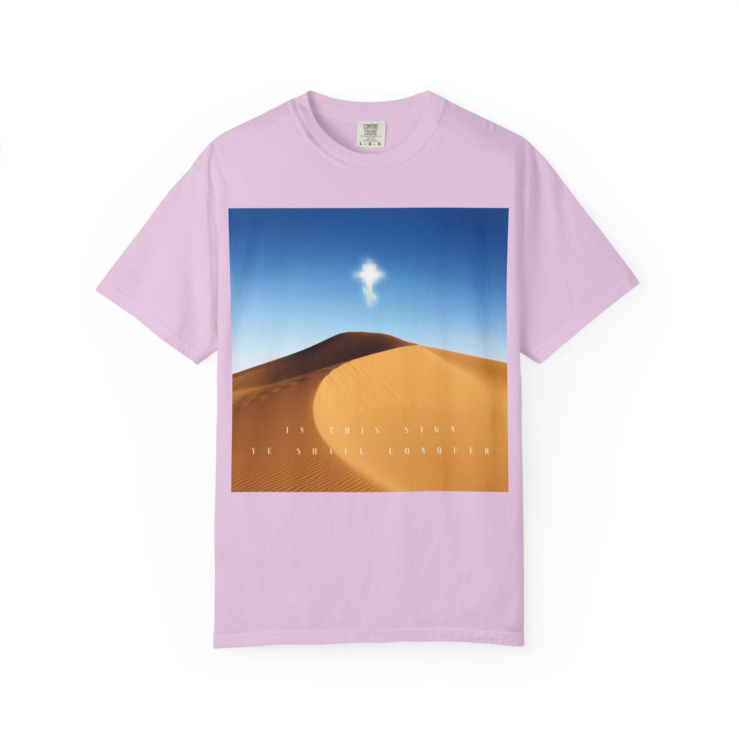 Orchid t-shirt featuring a desert sun scene with a radiant cross illuminating the sky, symbolizing "The Cross is the Might of Kings," and text below the image reflecting "In This Sign Ye Shall Conquer"—celebrating the Beauty of the Orthodox Christian Faith.