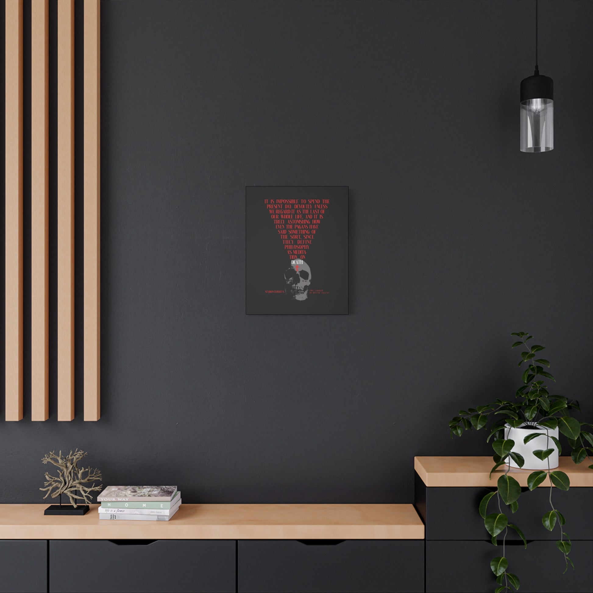 A modern black wall features "The Present Day As the Last Day of Our Life" Orthodox canvas art—skull with red cross, symbolizing memento mori—paired with plants, books, and a decorative tree on wooden shelves.