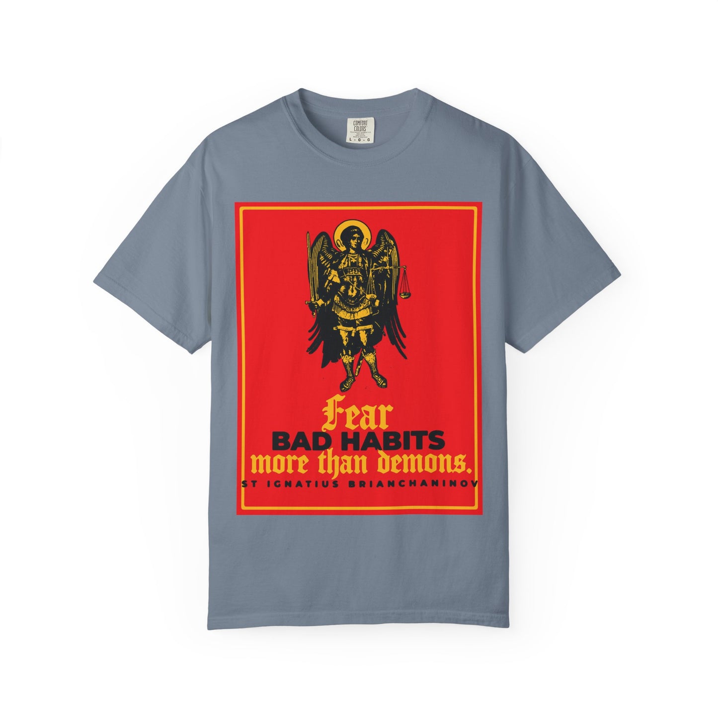 Blue Jean heavyweight cotton unisex tee featuring an Archangel Michael icono-graphic and the phrase “Fear bad habits more than demons,” inspired by St. Ignatius Brianchaninov, symbolizing the ongoing spiritual battle between moral freedom and temptation.